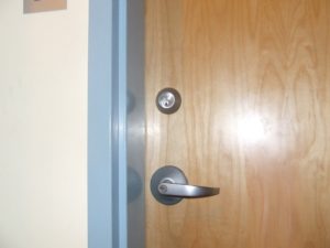 Interior apartment building door with deadbolt and lever handle—commonly rekeyed during move-ins or tenant turnovers.