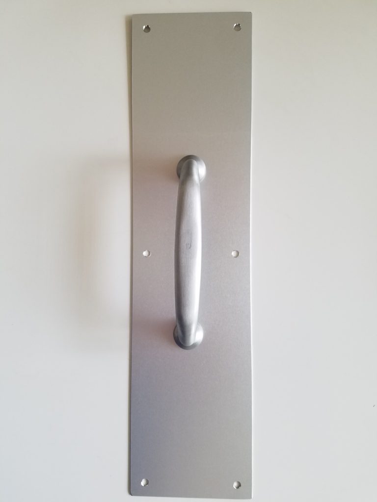 Pull handle with backplate used on commercial entry doors with manual access setups.