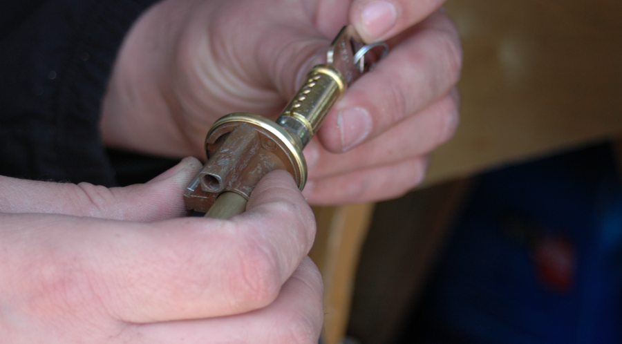 Locksmith rekeying a residential door lock cylinder during an on-site service in Denver.